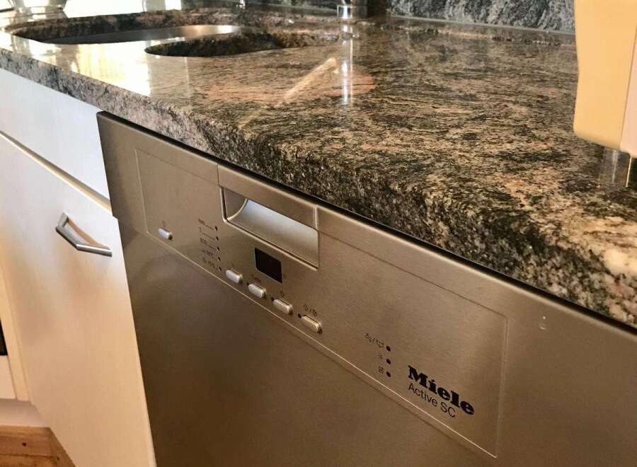 This stunning kitchen boasts a sleek, modern design with a beautiful granite countertop.