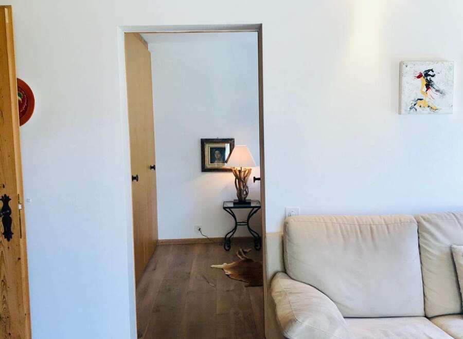 Discover a cozy living space with a warm wooden ceiling and inviting hardwood floors.