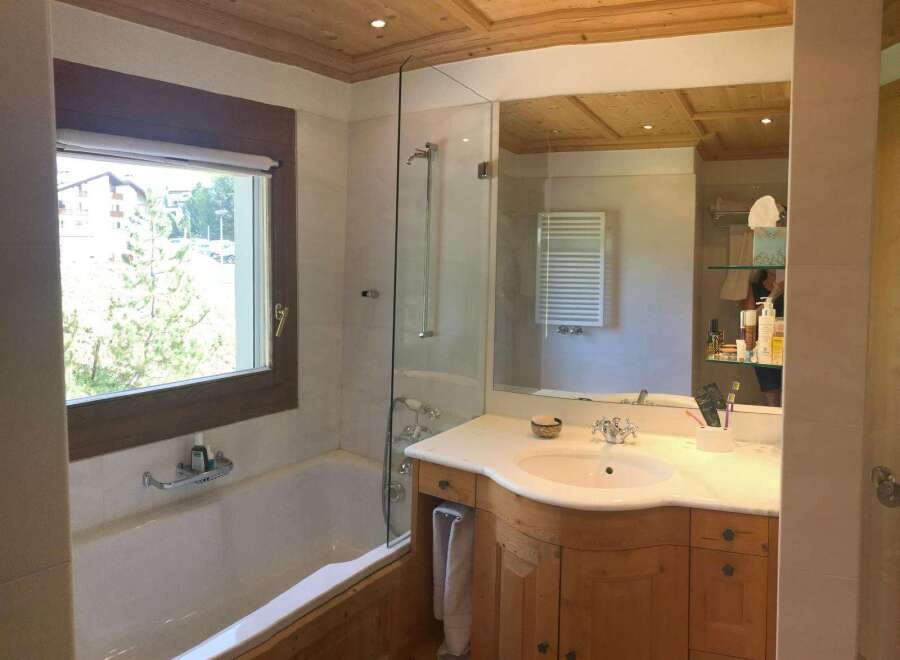 This luxurious bathroom features a stunning wooden ceiling and a spacious bathtub, creating a warm and inviting atmosphere.