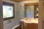 This luxurious bathroom features a stunning wooden ceiling and a spacious bathtub, creating a warm and inviting atmosphere.