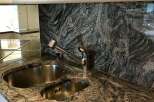 This stunning kitchen boasts a beautiful granite countertop and backsplash, creating a luxurious and durable workspace.