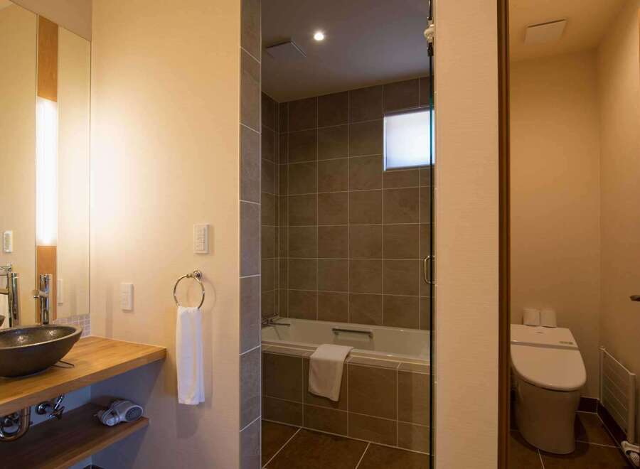 This luxurious bathroom boasts a spacious walk-in shower with modern fixtures and a sleek, minimalist design.