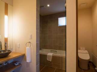 This luxurious bathroom boasts a spacious walk-in shower with modern fixtures and a sleek, minimalist design.