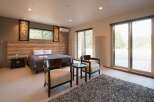 This stunning bedroom boasts a king-size bed, plush carpeting, and large windows offering breathtaking views of the surrounding landscape.