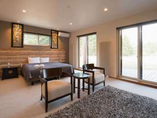 This stunning bedroom boasts a king-size bed, plush carpeting, and large windows offering breathtaking views of the surrounding landscape.