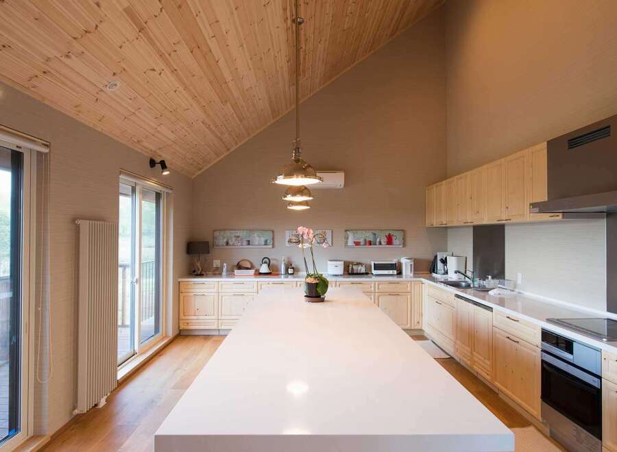 This stunning kitchen boasts a spacious island with white countertops, perfect for meal prep and entertaining.