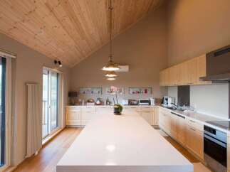 This stunning kitchen boasts a spacious island with white countertops, perfect for meal prep and entertaining.