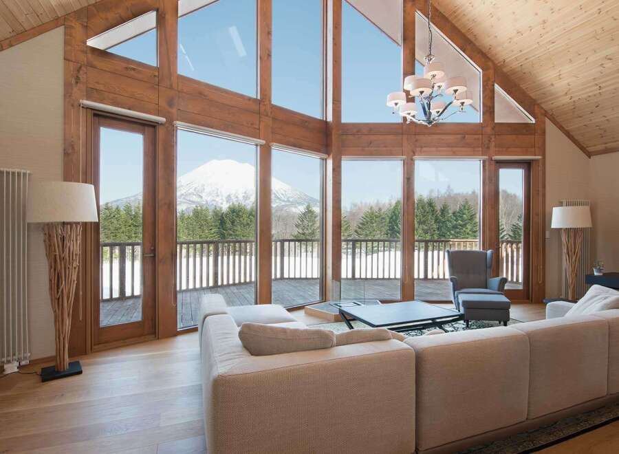 Luxury mountain lodge with wall-to-wall windows showcasing breathtaking views.