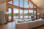 Luxury mountain lodge with wall-to-wall windows showcasing breathtaking views.