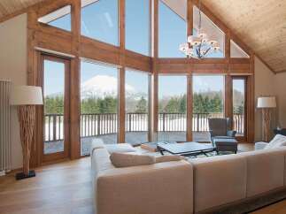 Luxury mountain lodge with wall-to-wall windows showcasing breathtaking views.
