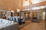 This stunning property boasts a spacious open-plan living area with high ceilings and exposed wooden beams, creating a warm and inviting atmosphere.