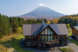 This stunning log cabin boasts a spacious layout with expansive windows offering breathtaking views of the surrounding mountain landscape.