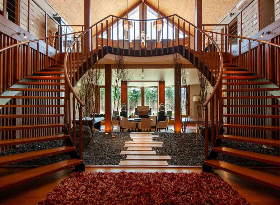 This stunning property boasts a unique architectural design, featuring two elegant curved staircases that frame a serene interior courtyard.