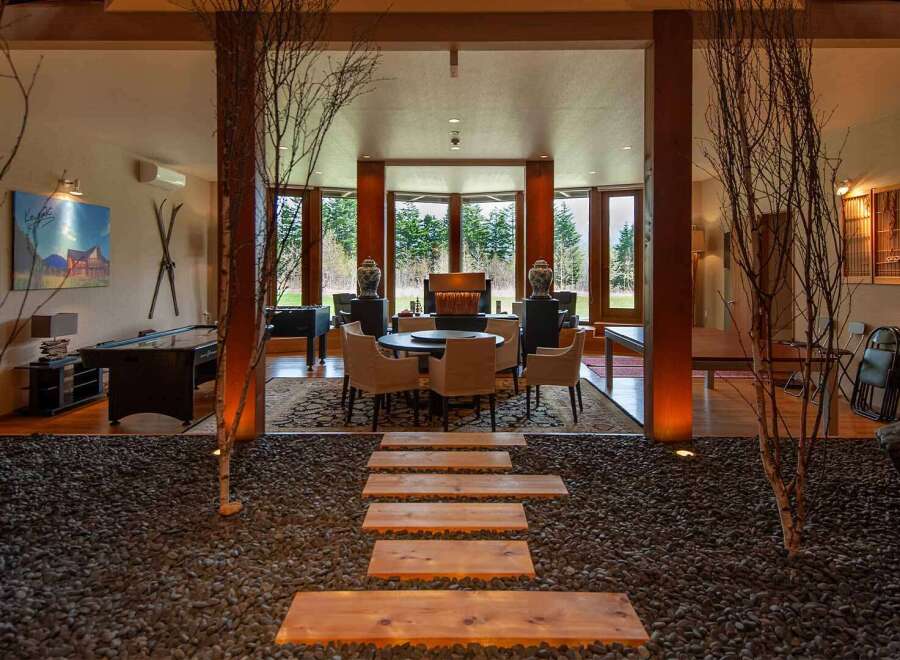 This stunning property boasts a unique blend of modern and traditional design, featuring a spacious open-plan living area with floor-to-ceiling windows offering breathtaking views.