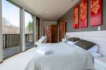 Wake up to breathtaking views from this luxurious bedroom, featuring floor-to-ceiling windows showcasing a stunning mountain landscape.