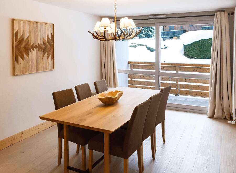 This stunning apartment boasts a spacious dining area with a large wooden table, perfect for family meals.