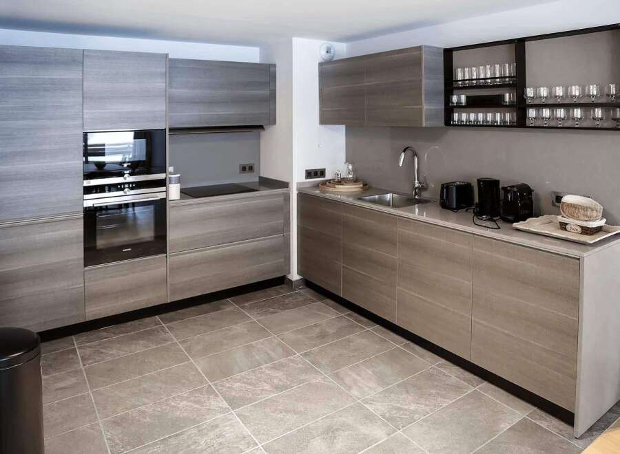 Modern kitchen with sleek gray cabinets and integrated appliances.