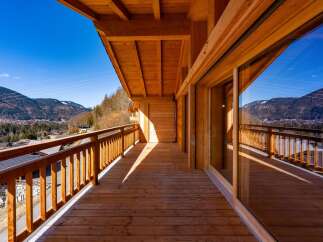 Experience breathtaking mountain views from this stunning wooden balcony.