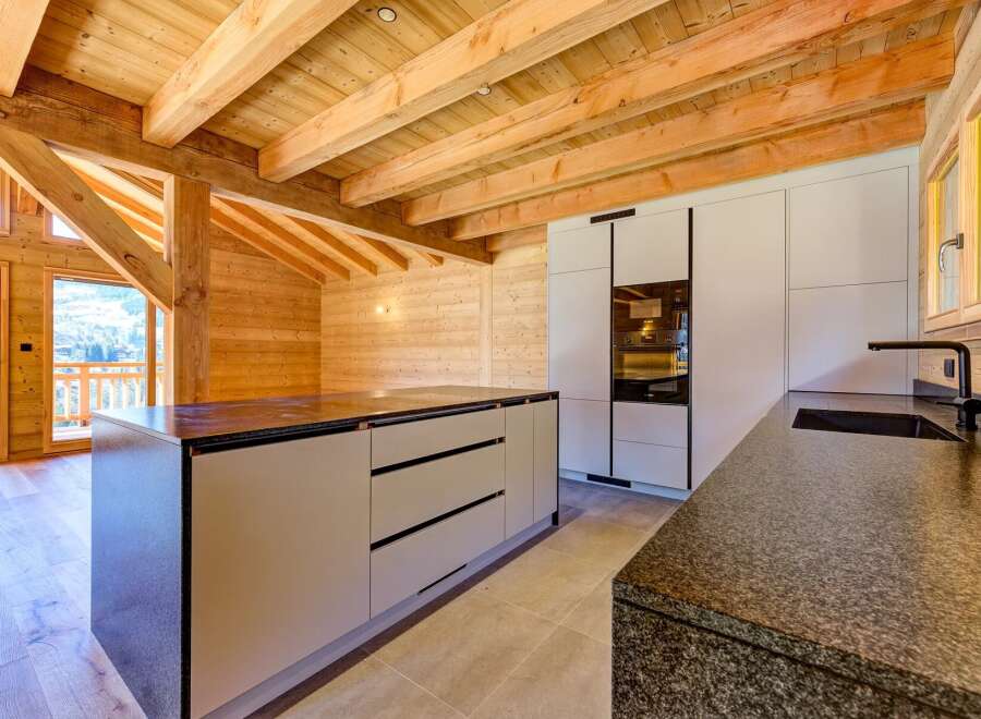 Experience the warmth of this stunning kitchen, featuring exposed wooden beams and a modern design.
