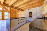 Experience the warmth of this stunning kitchen, featuring exposed wooden beams and a modern design.