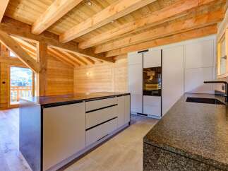 Experience the warmth of this stunning kitchen, featuring exposed wooden beams and a modern design.