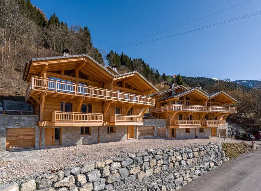 Discover luxury living in these stunning wooden chalets nestled in a picturesque mountain setting.