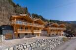 Discover luxury living in these stunning wooden chalets nestled in a picturesque mountain setting.