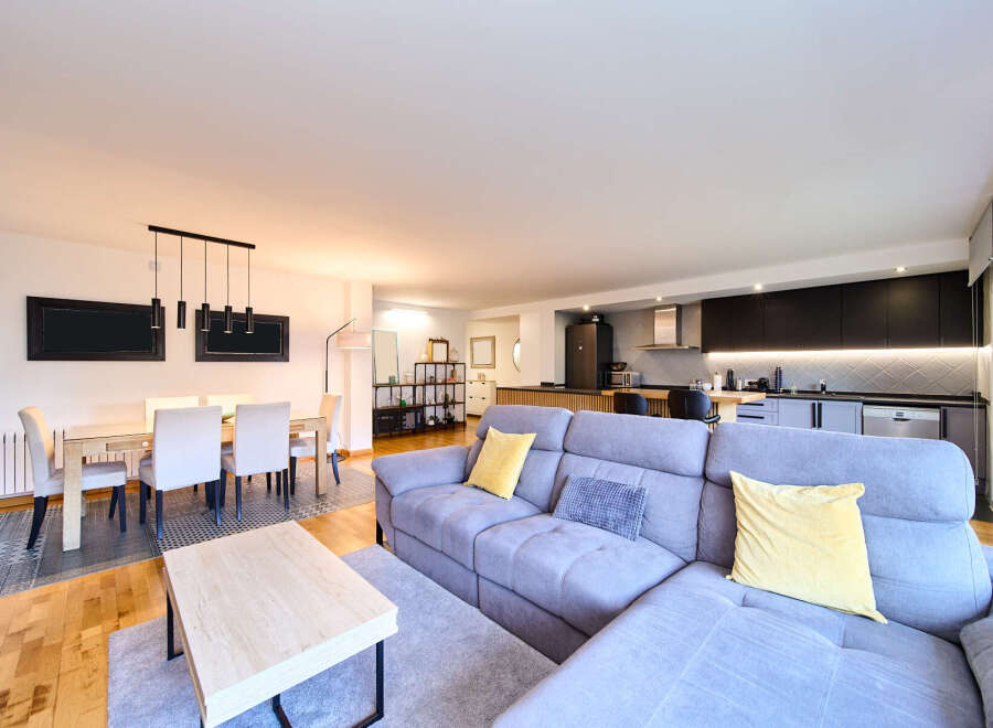 Stunning open-plan living space featuring a modern kitchen, spacious dining area, and comfortable L-shaped sofa.