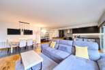 Stunning open-plan living space featuring a modern kitchen, spacious dining area, and comfortable L-shaped sofa.