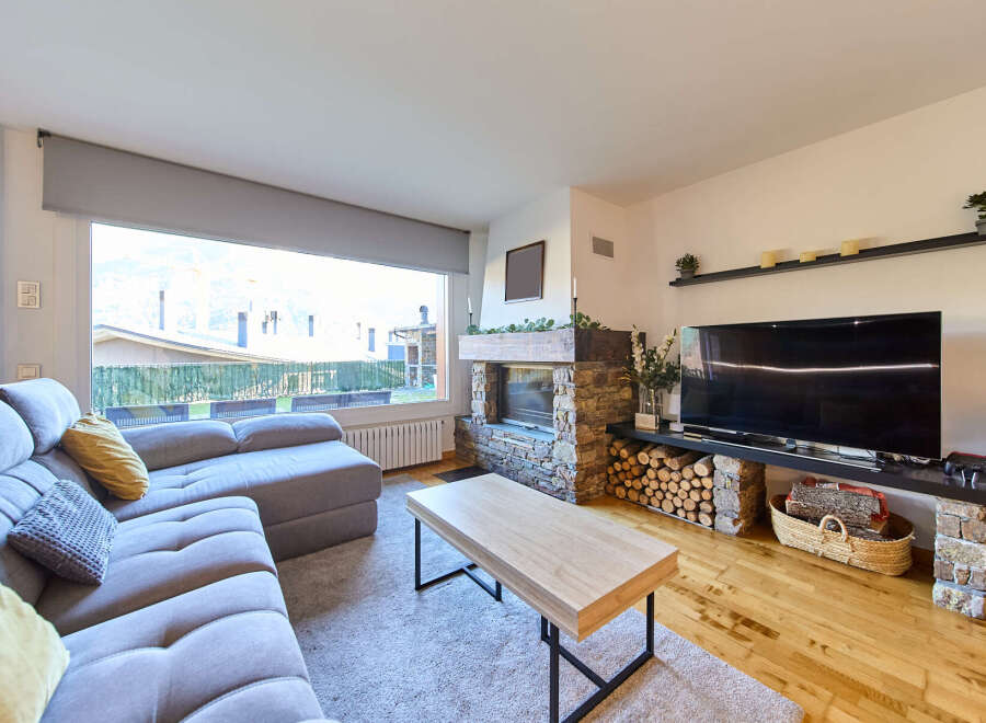 Cozy living room with a stone fireplace and large windows offering scenic views.