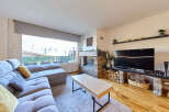 Cozy living room with a stone fireplace and large windows offering scenic views.