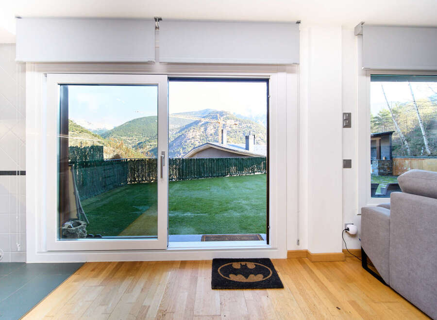 This stunning property boasts floor-to-ceiling sliding doors that open to a private garden with mountain views.