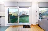This stunning property boasts floor-to-ceiling sliding doors that open to a private garden with mountain views.