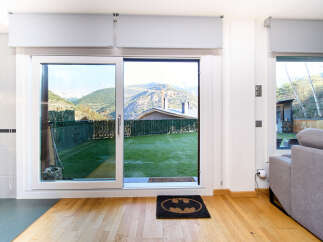 This stunning property boasts floor-to-ceiling sliding doors that open to a private garden with mountain views.