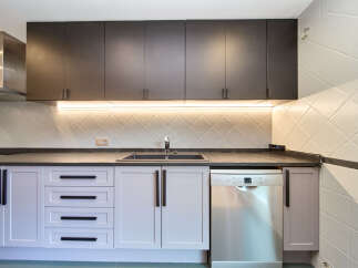 Modern kitchen with dark gray upper cabinets and light purple lower cabinets.