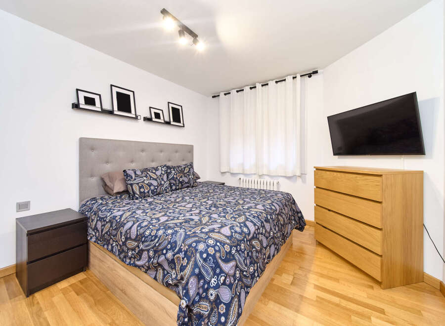 Bright and airy bedroom with a comfortable double bed, featuring a stylish paisley duvet cover.