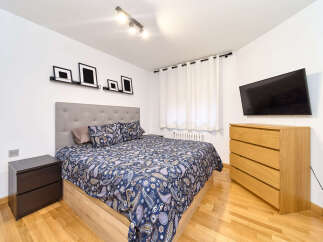 Bright and airy bedroom with a comfortable double bed, featuring a stylish paisley duvet cover.