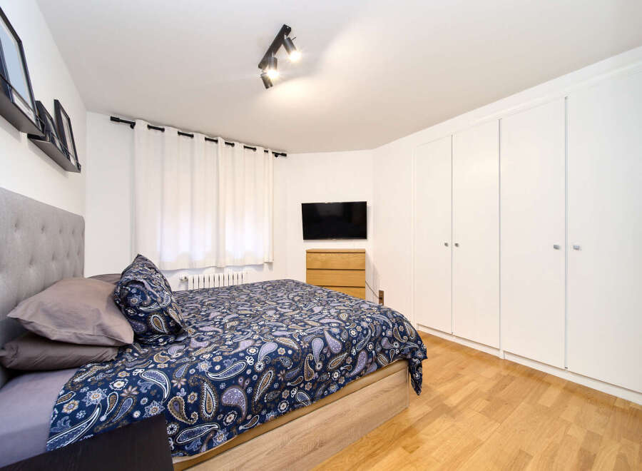 Bright and airy bedroom with hardwood floors and built-in wardrobes.