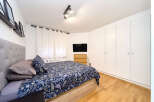 Bright and airy bedroom with hardwood floors and built-in wardrobes.