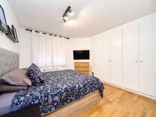 Bright and airy bedroom with hardwood floors and built-in wardrobes.
