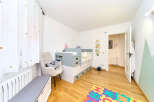 Delightful nursery with built-in crib and changing station, offering ample storage.