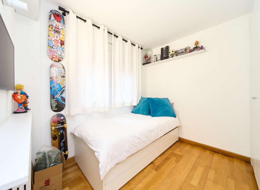 Cozy bedroom with built-in storage and hardwood floors.