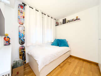 Cozy bedroom with built-in storage and hardwood floors.