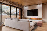 This stunning property boasts a spacious living area with floor-to-ceiling windows offering breathtaking mountain views.