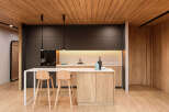 Modern kitchen with dark gray cabinets and light wood island, creating a stylish contrast.