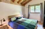 Discover a cozy bedroom with a wooden ceiling, creating a warm and inviting atmosphere.