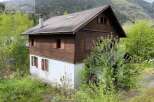 Discover a charming wooden house nestled in a picturesque mountain setting.