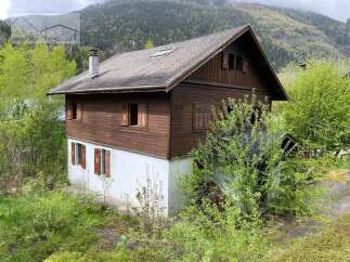 Discover a charming wooden house nestled in a picturesque mountain setting.