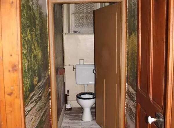 Explore this charming property featuring a unique hallway leading to a cozy bathroom.