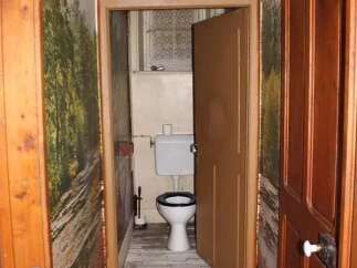 Explore this charming property featuring a unique hallway leading to a cozy bathroom.